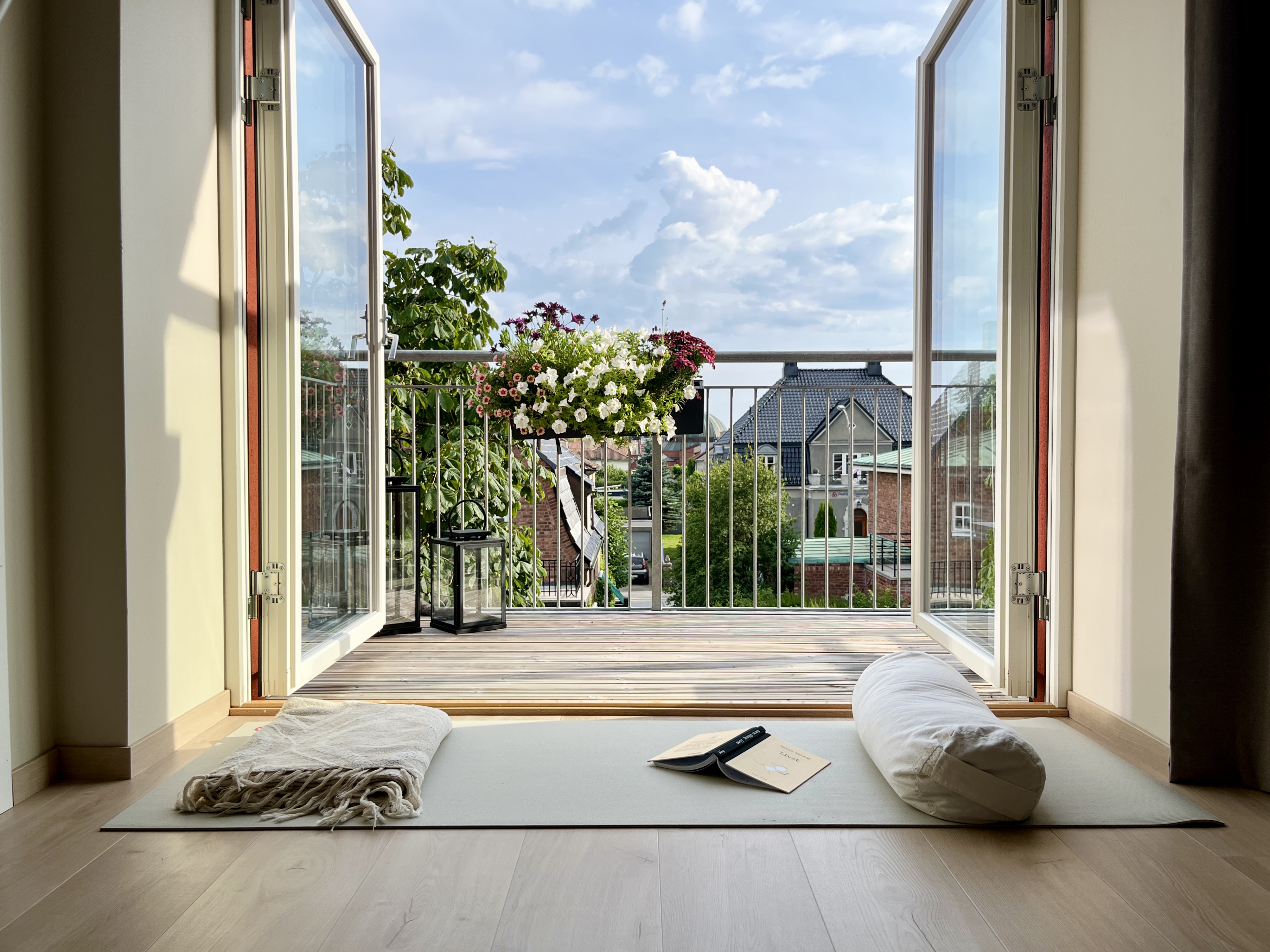 Yogamatte, pledd og bolster foran åpen dør