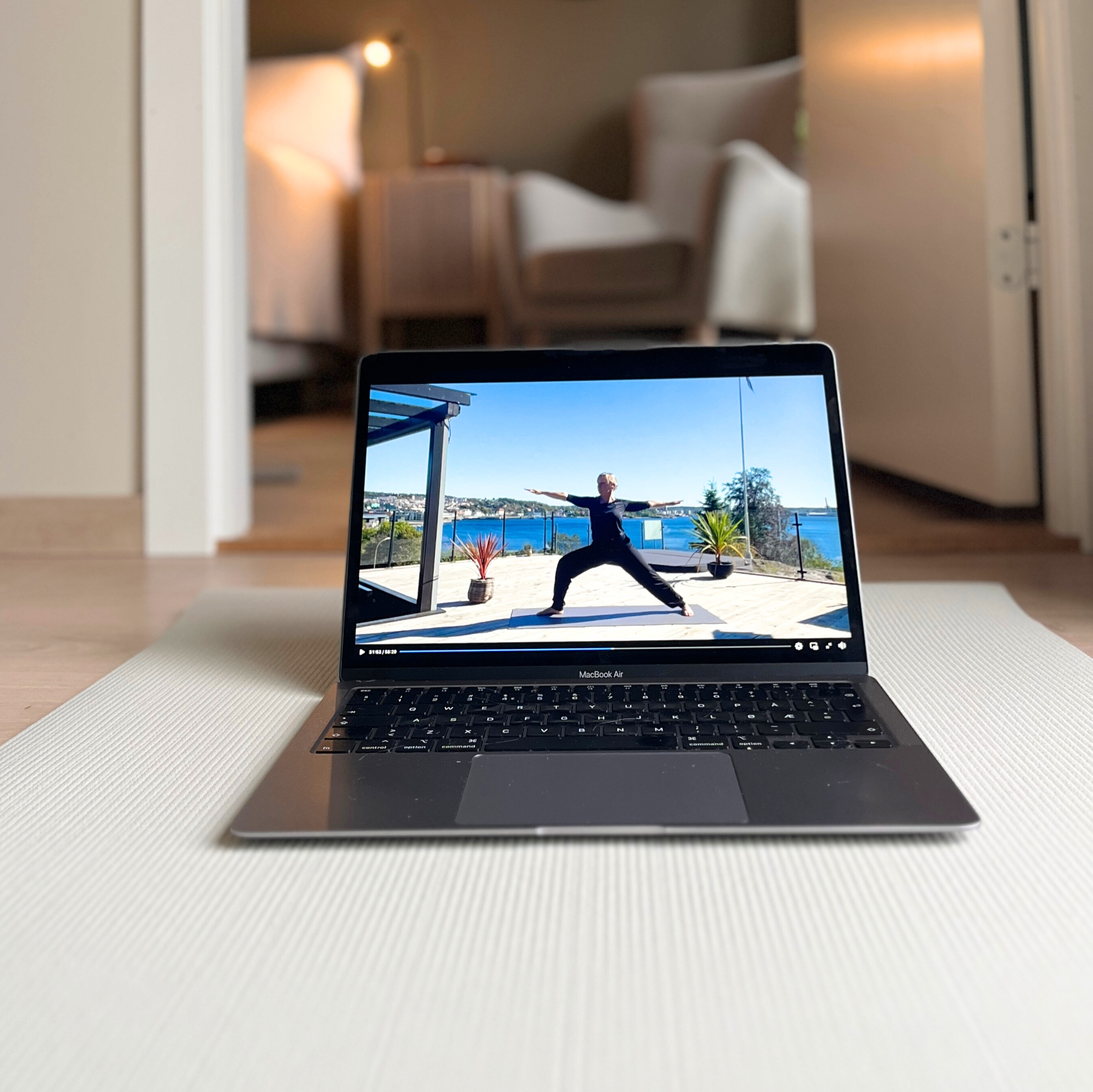 Laptop med yogavideo på matte - digitalt medlemskap i hjemmet